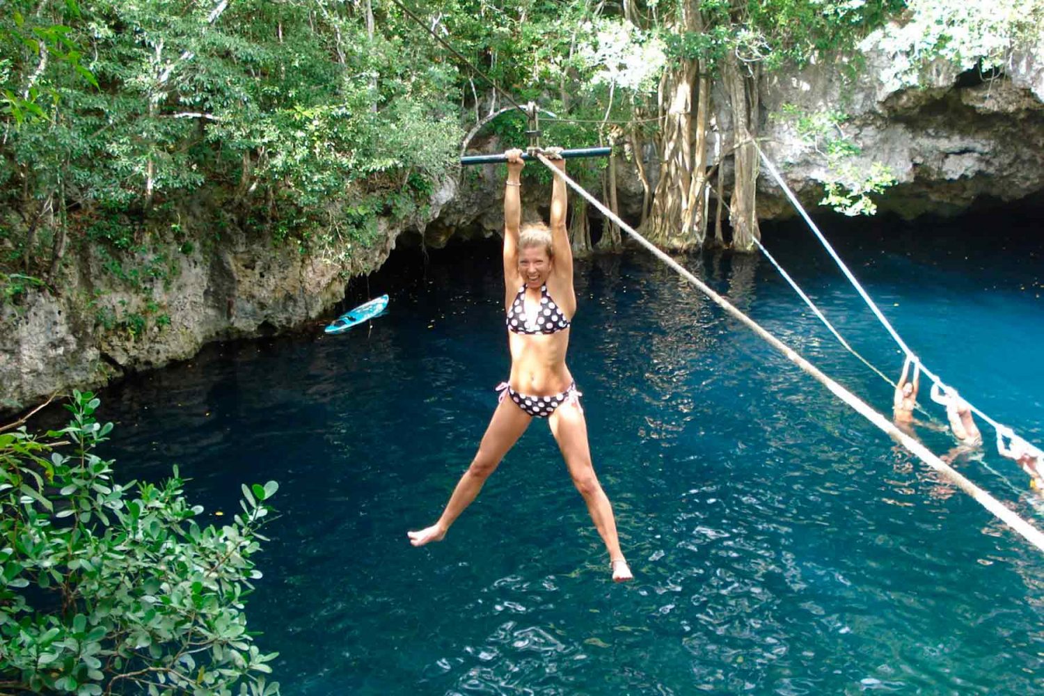 Chica en tirolesa sobre cenote